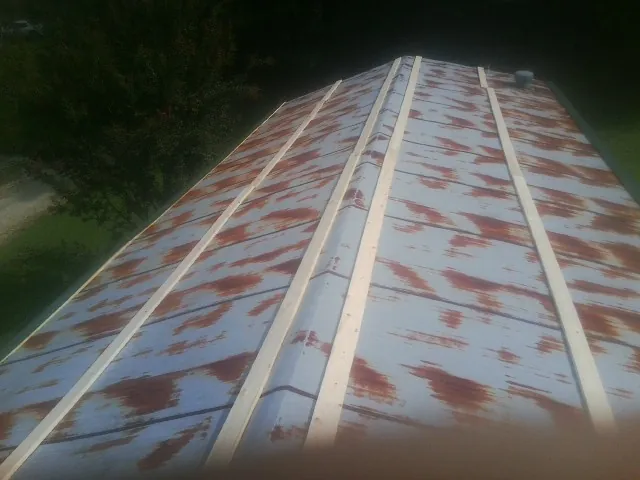 Rusted metal roof panels with new wood purlins before replacement — Storm Damage Roof Repair in Richardsville by Roofing Brothers
